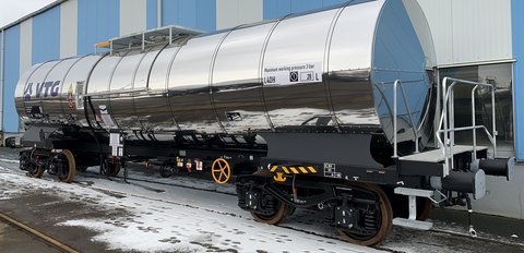 Silver tank wagon in front of blue hall