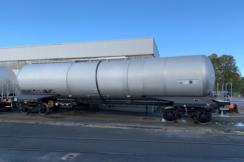 Gray tank car with lettering in front of hall