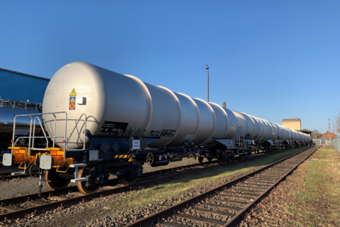 Gray tank car on track under a blue sky