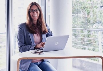 Laughing VTG employee at table with laptop